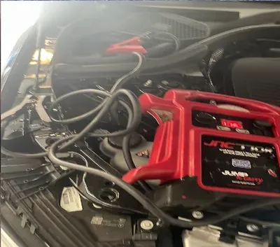 Portable jump pack connected to a dead battery